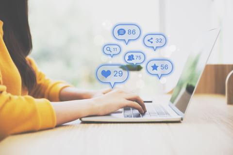 a person typing on the computer with numerical icons hovering over 