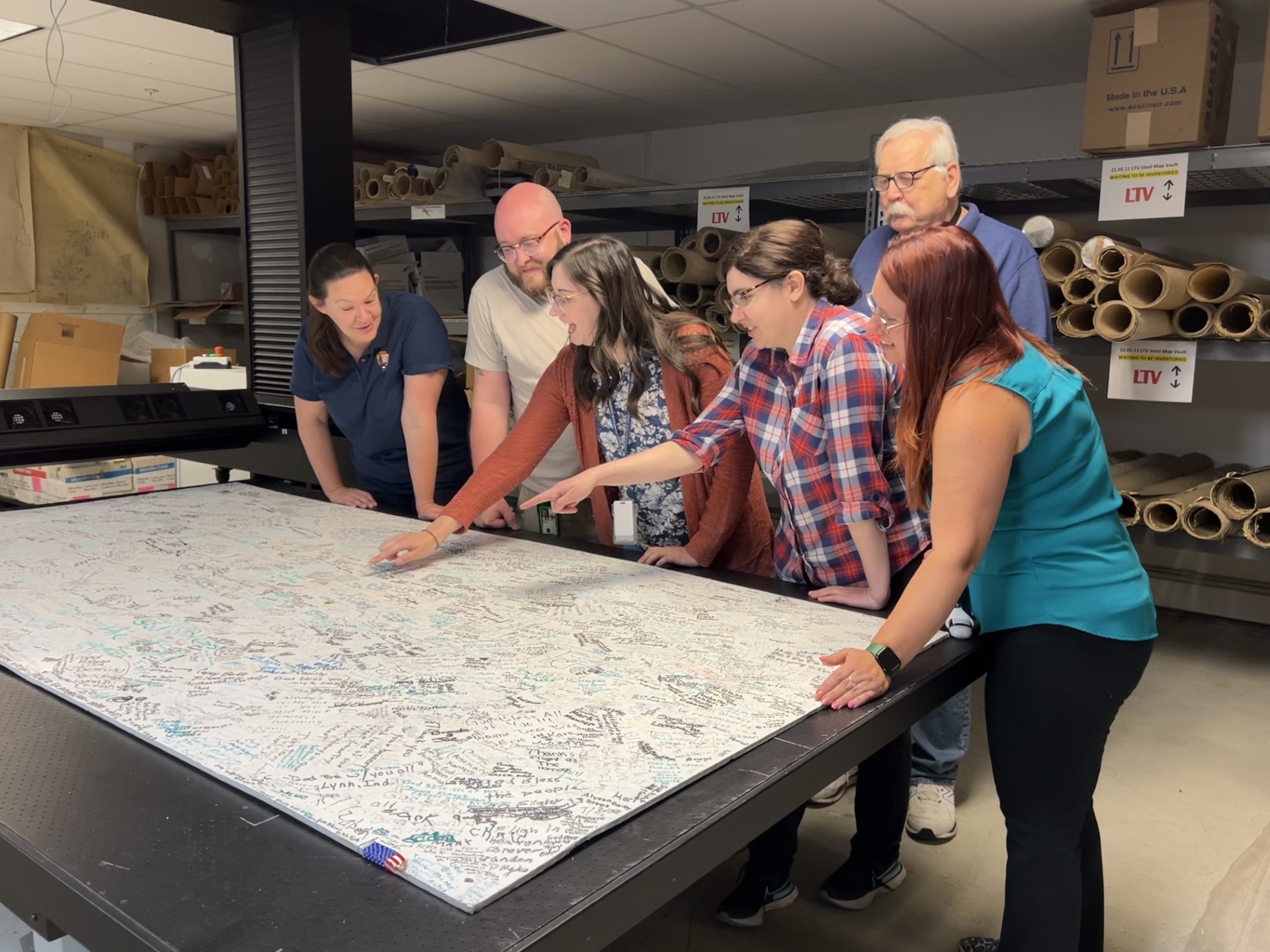 NMMR staff members Harrison Kinzler, Chelsea Solotky, Beth Spindler, Jessica Reitz and retired employee Paul Coyle, along with Western Pennsylvania parks curator Elizabeth Keene, view signed Flight 93 boards being scanned by NMMR.