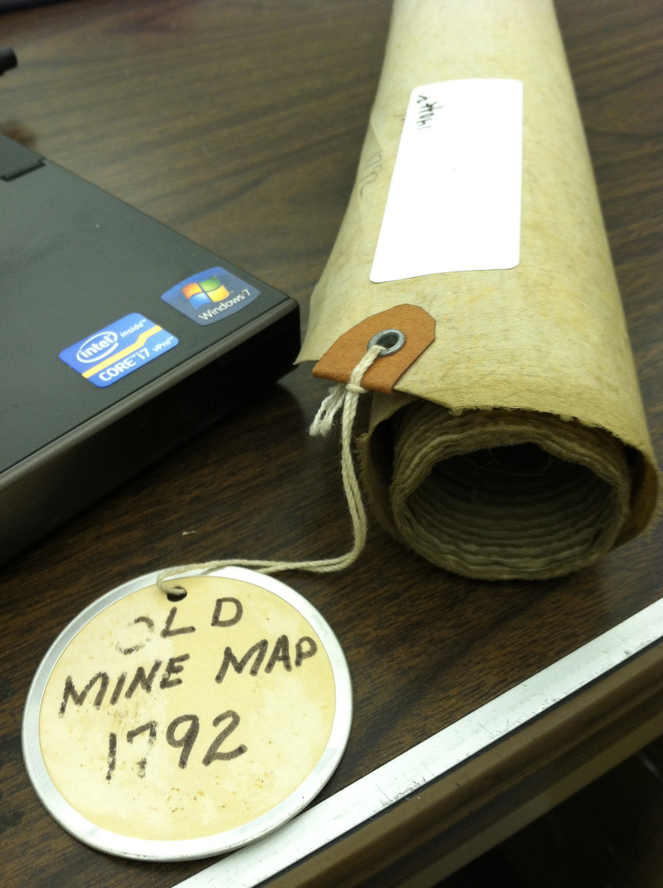 An old mine map rolled up on a desk.