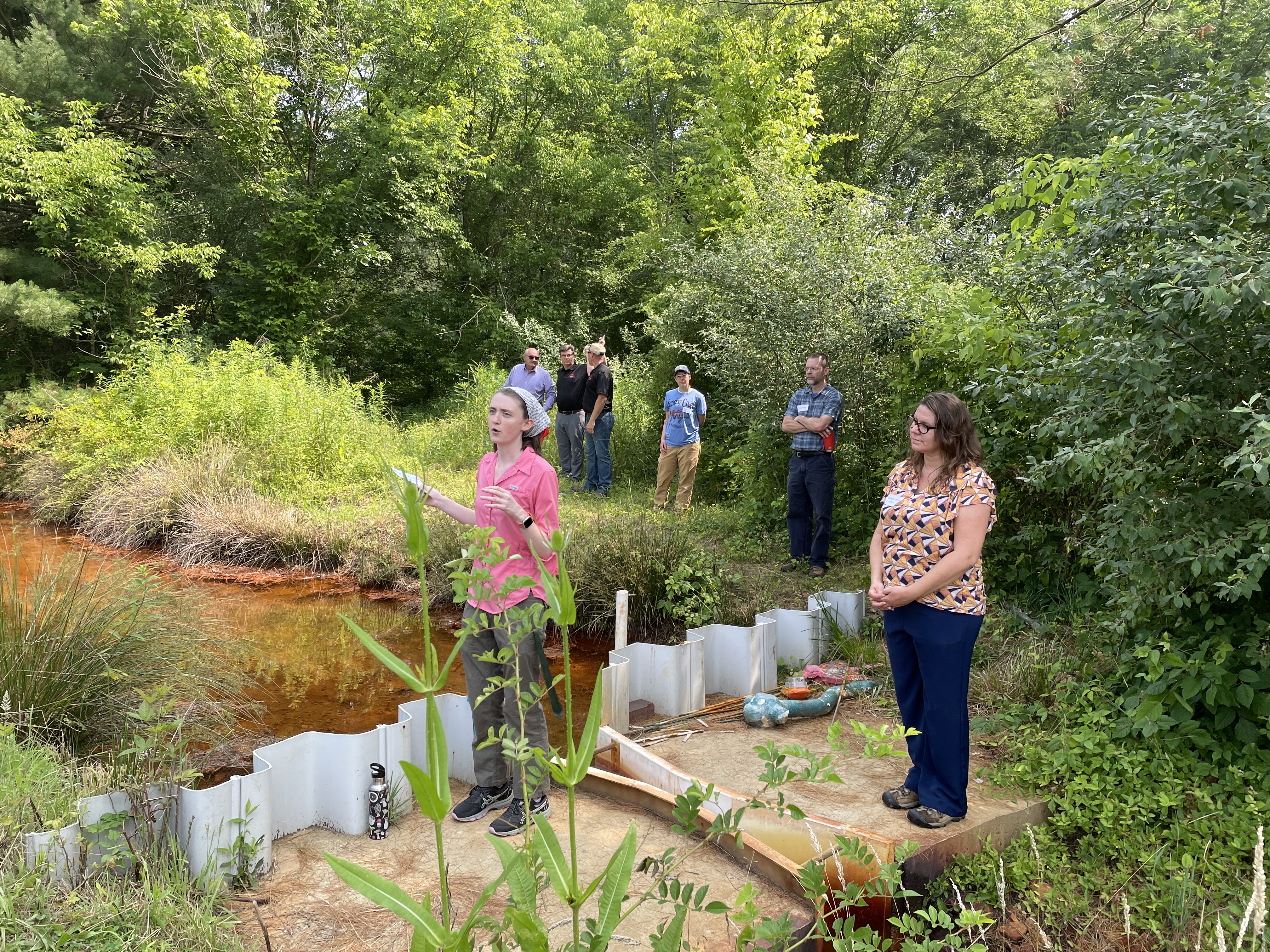 Elizabeth Myers, an Ohio University civil engineering graduate student, speaks to attendees at a groundbreaking ceremony in Millfield, Ohio, June 29, as Michelle Shively Maclver, Rural Action and True Pigments, LLC’s director of project management looks on.