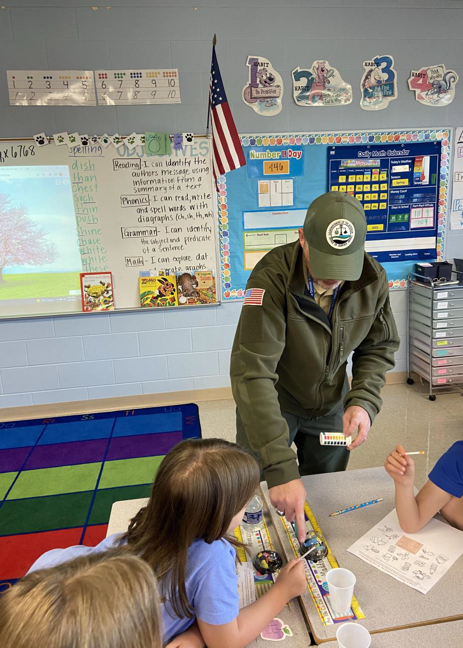 Students using non-toxic pH test strips to test several everyday liquids, including tap water, Coca-Cola, and vinegar, to figure out where each one falls on the pH scale.