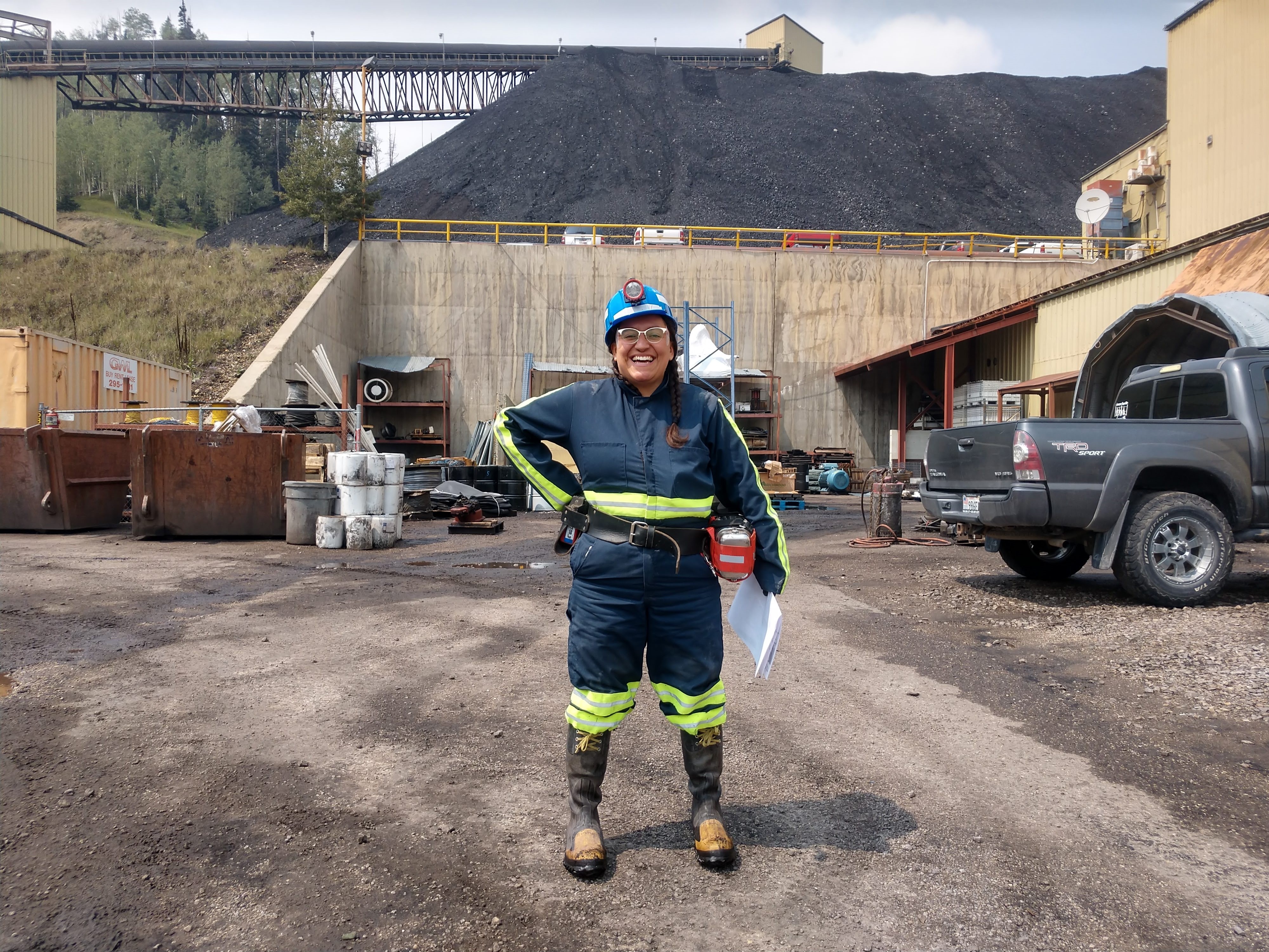 Bobbi Martinez Hernandez in field attire stands at a coal mine site.
