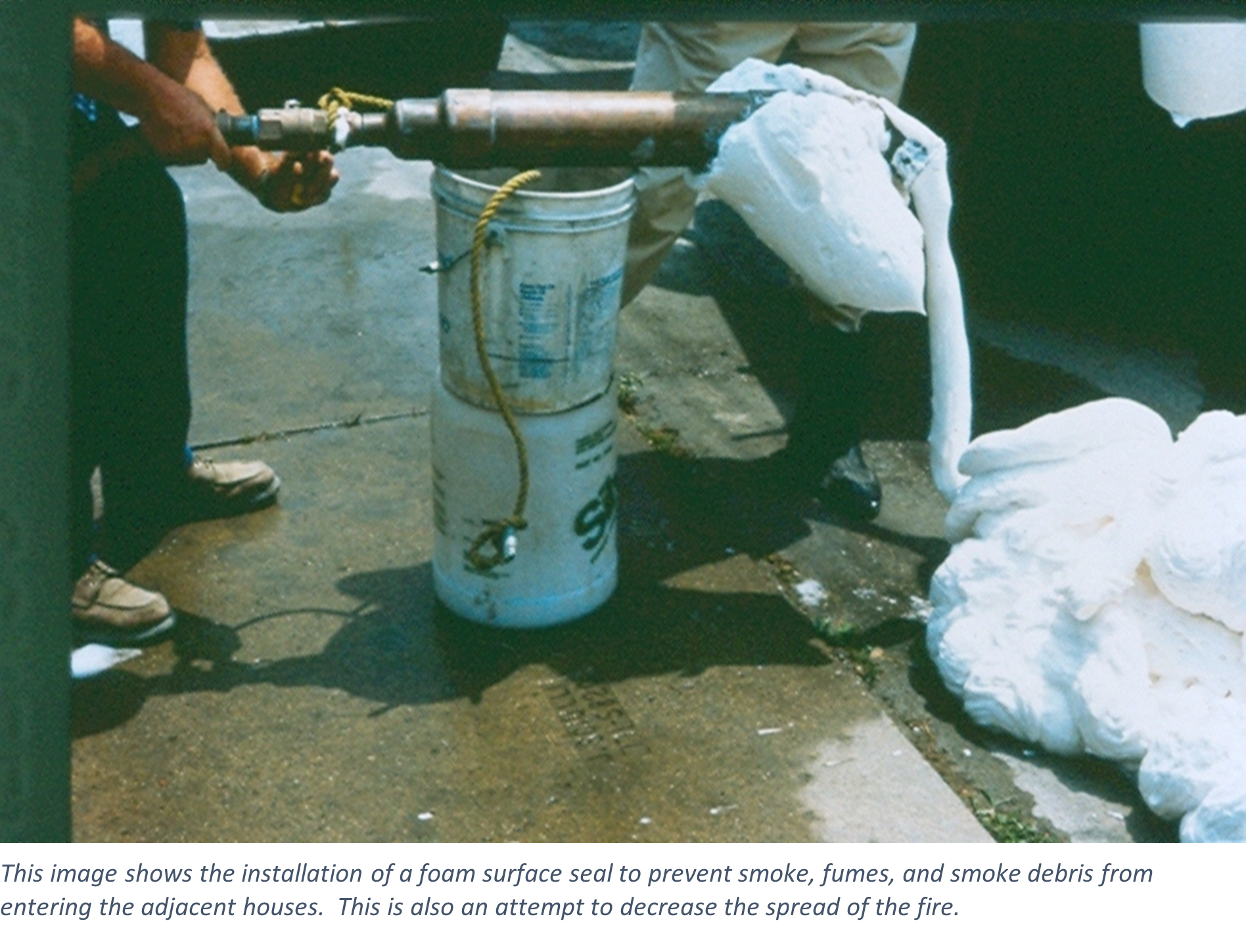 This image shows the installation of a foam surface seal to prevent smoke, fumes, and smoke debris from entering the adjacent houses.  This is also an attempt to decrease the spread of the fire.
