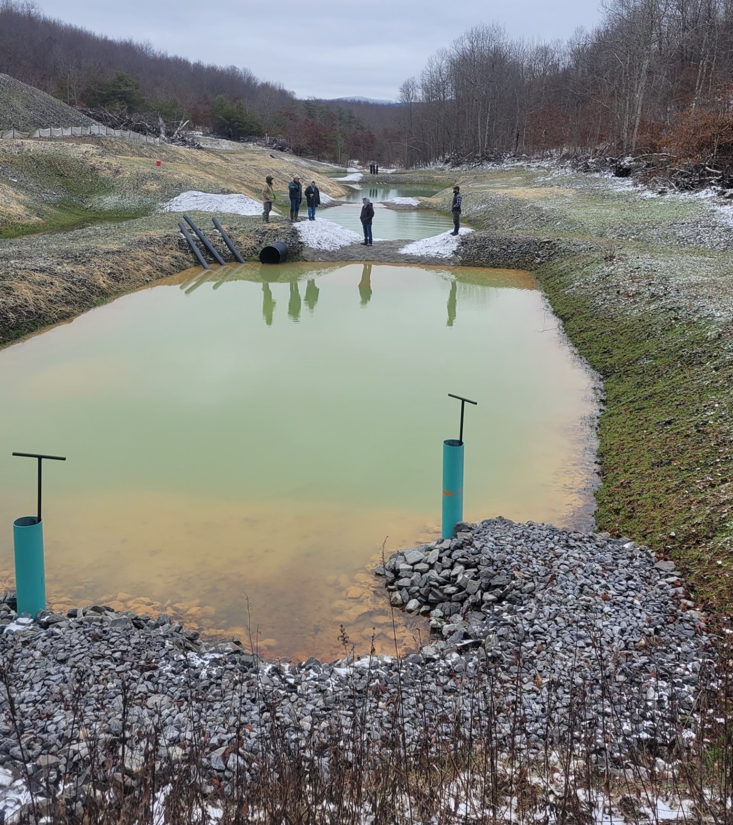 Acid mine drainage reclamation project, showing three ponds and people in the background