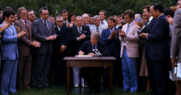 A photo of President Jimmy Carter signing the Surface Mining Control and Reclamation Act of 1977 during a signing ceremony.