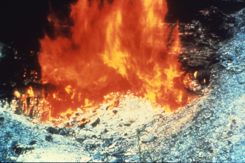 This example is a burning coal seam where it outcrops.  With the fire at the coal seam outcrop, there is plenty of oxygen in the air to cause the fire to burn rapidly with large flames.  As the fire advances underground, the available oxygen will diminish limiting flame height and the fire takes on a smoldering appearance.