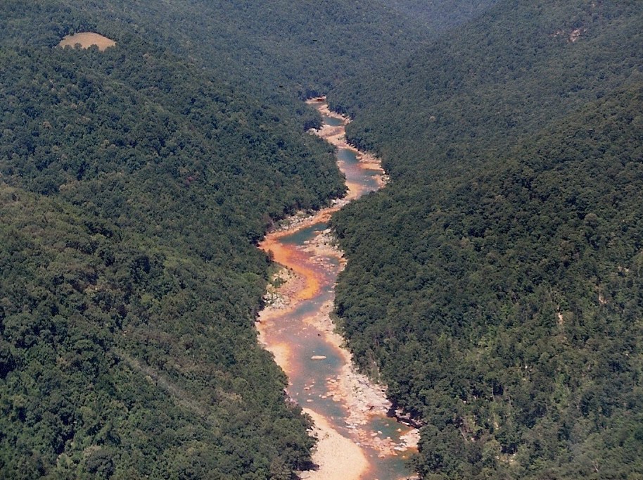 An orange river runs through a valley.