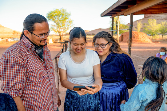 Image of Navajo Family Spending Time Sharing Photos from a Smart Phone