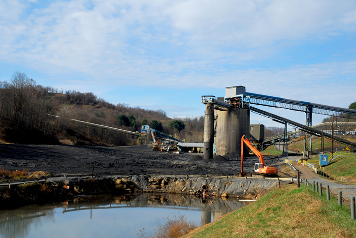 Image of a coal mine in West Virginia; in the foreground there is a water body at the base of a mine.