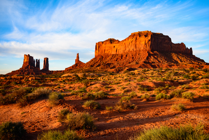 Image of Monument Valley Navajo Tribal Park; a red/orange rock face in the desert in Navajo