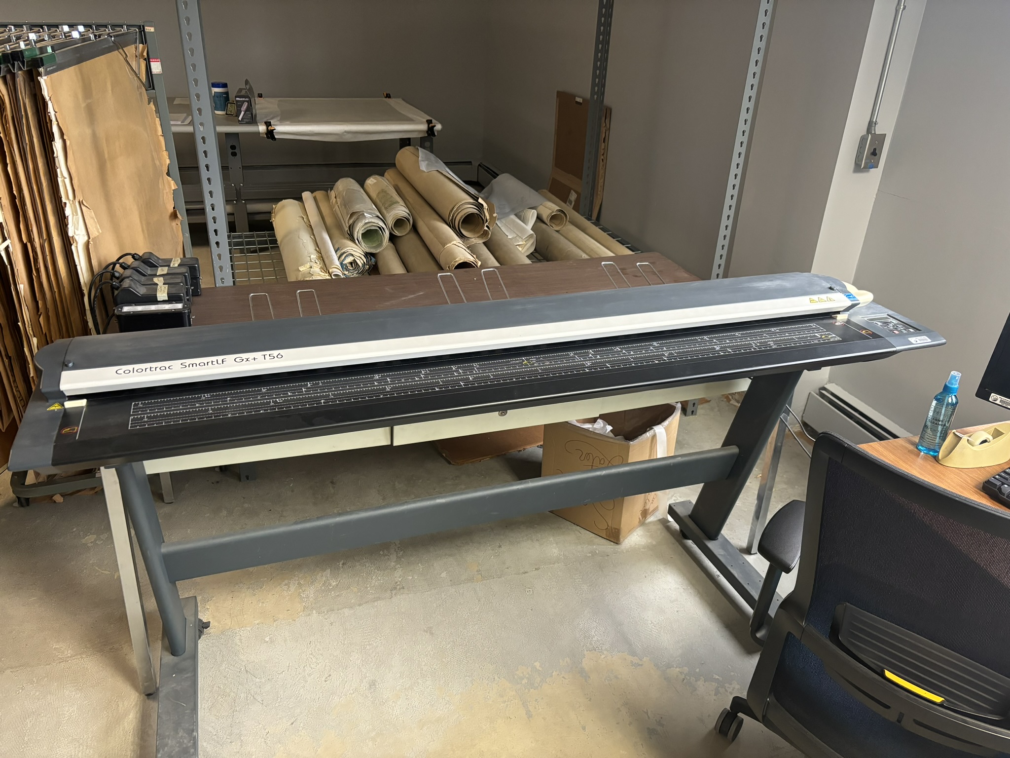 Photo of roll scanner. Rolled maps in background.