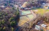 An aerial image shows three water treatment ponds surrounded by forest, field and infrastructure