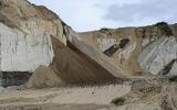 Steep and jagged, tan-colored highwalls jut out of an abandoned mine area near Healy Creek, AK